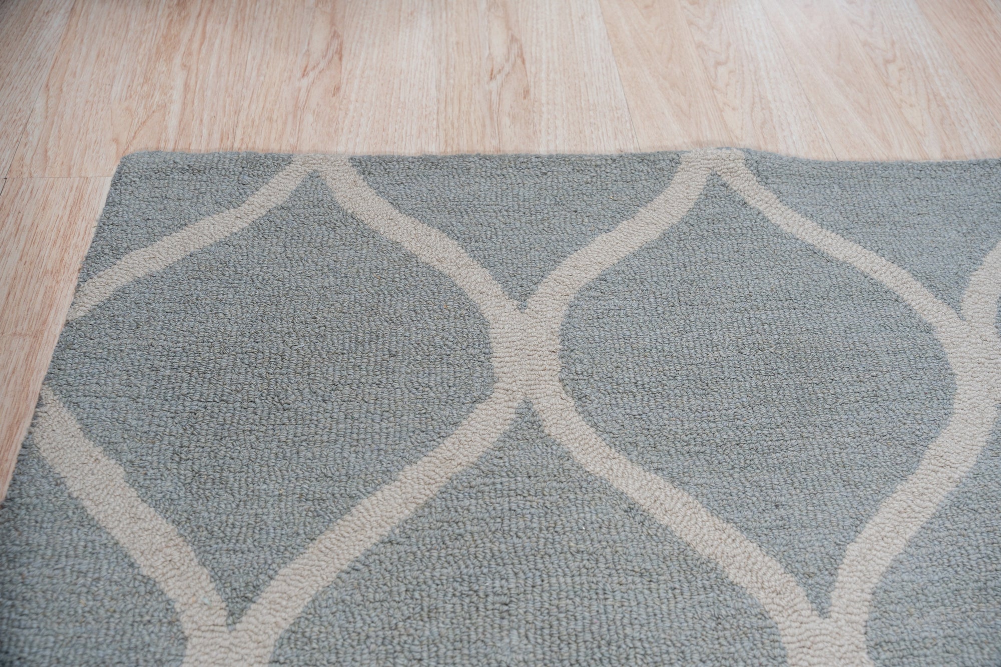 Handcrafted Laine Light Green Hand Tufted Wool Rug, a light green wool rug with a subtle textured design, displayed in a bright, naturally lit living space.