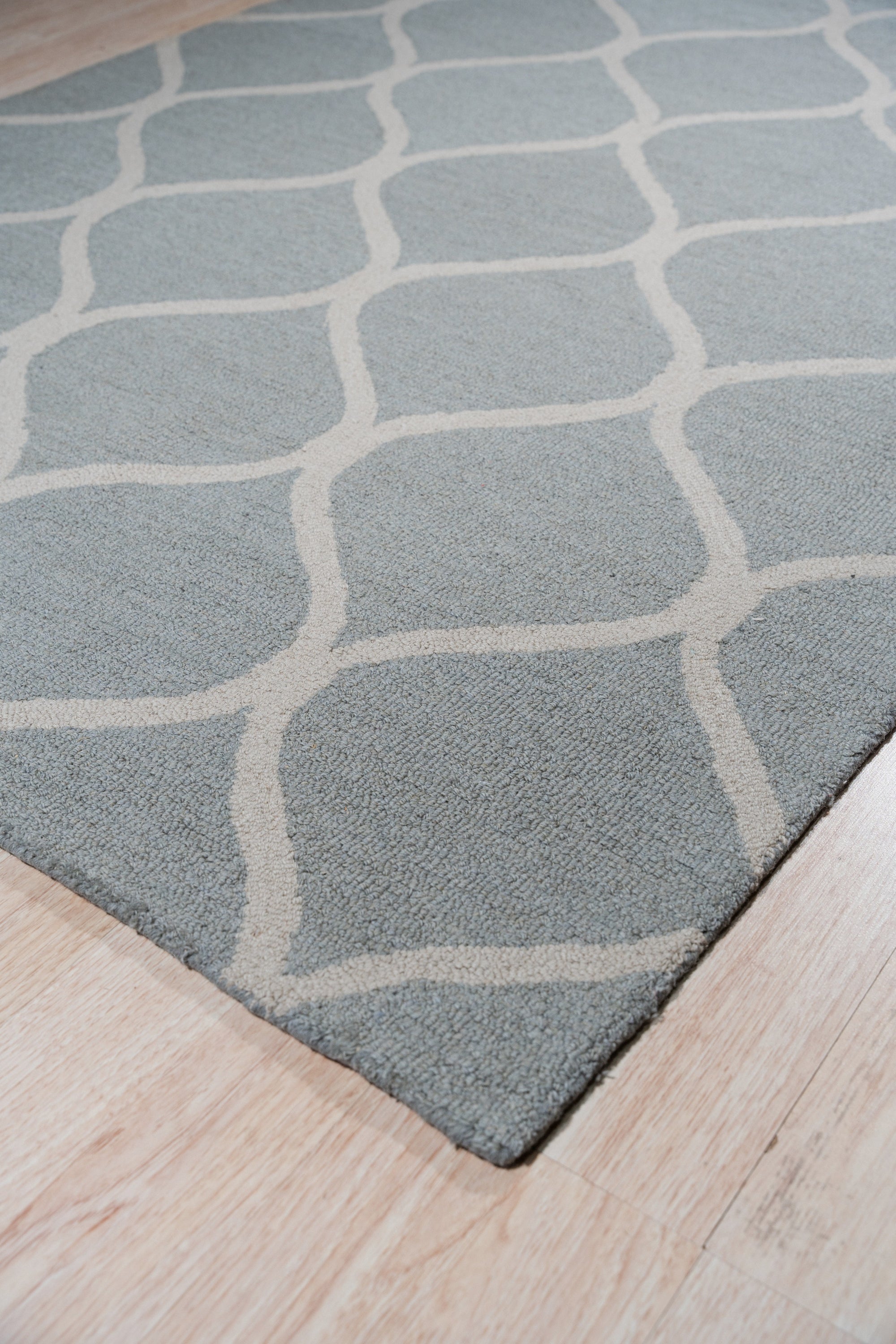Handcrafted Laine Light Green Hand Tufted Wool Rug, offering a serene splash of pale green, softening a bright, modern living room with its plush wool texture and inviting warmth.