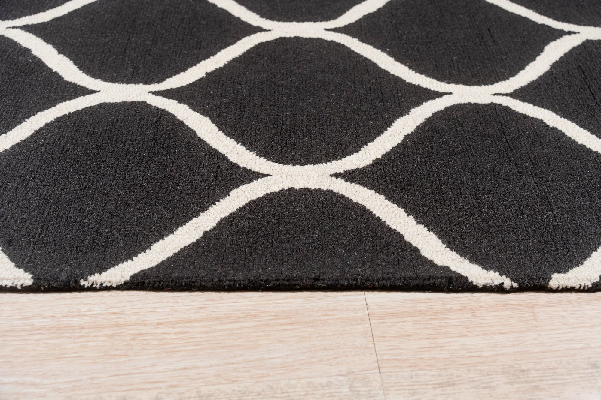 Sloane Willow Navy Hand Tufted Wool Rug graces a living room setting; the navy wool pile offers soft texture beneath furniture.