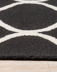 Sloane Willow Navy Hand Tufted Wool Rug anchors a living space, its deep navy hues and textural hand-tufted construction complementing light wood furniture and a cream sofa.