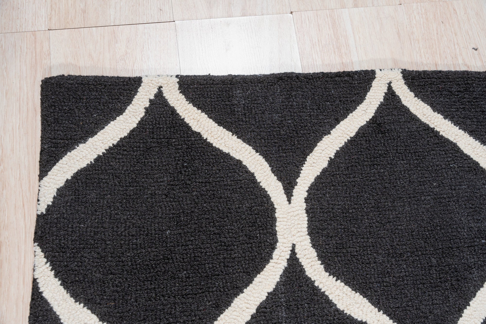 Sloane Willow Navy Hand Tufted Wool Rug in a living room setting; deep navy and cream tones accentuating a subtle willow leaf pattern in hand-tufted wool underfoot.