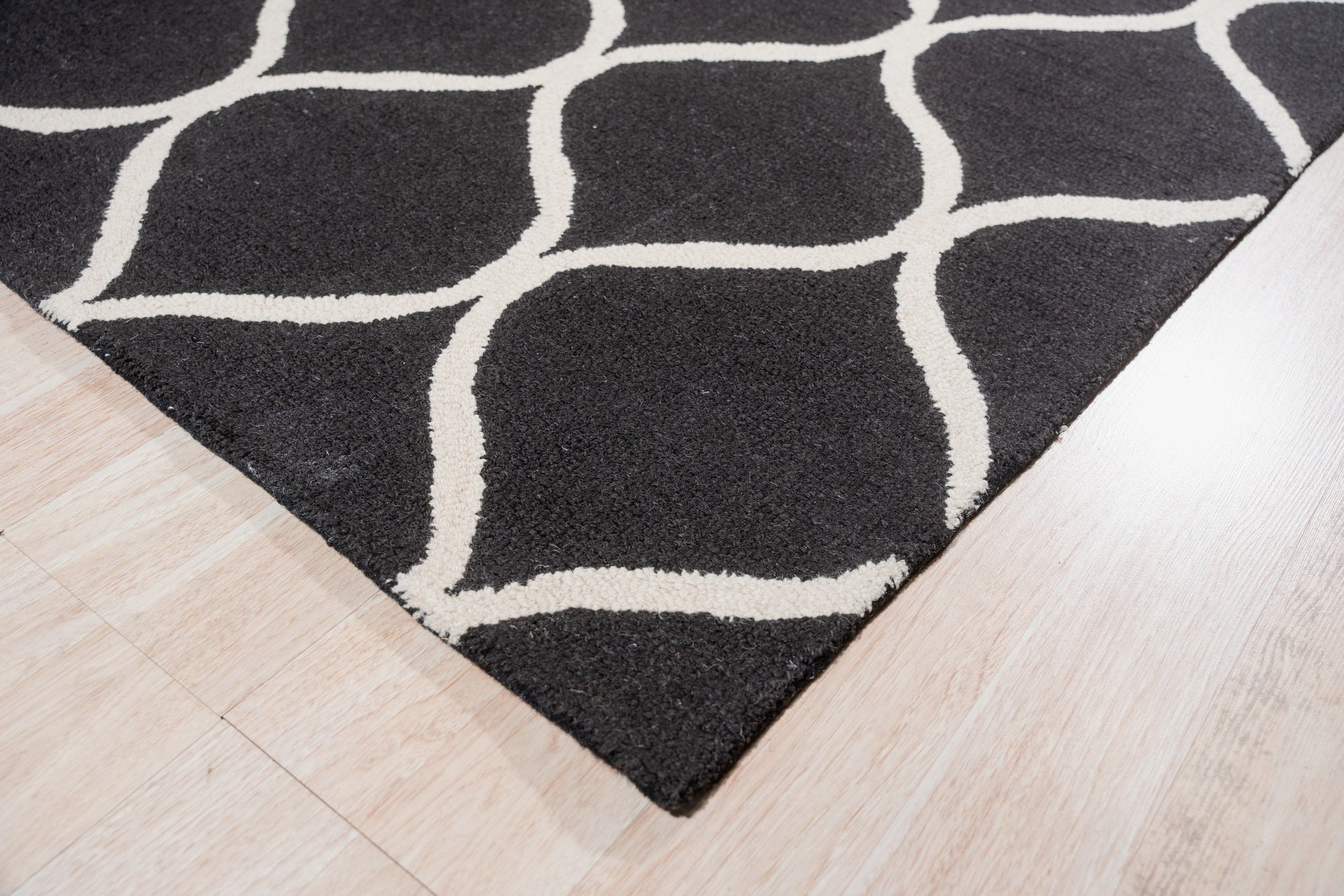 Sloane Willow Navy Hand Tufted Wool Rug, a navy wool rug with a willow-inspired design, seen in a brightly lit living space.
