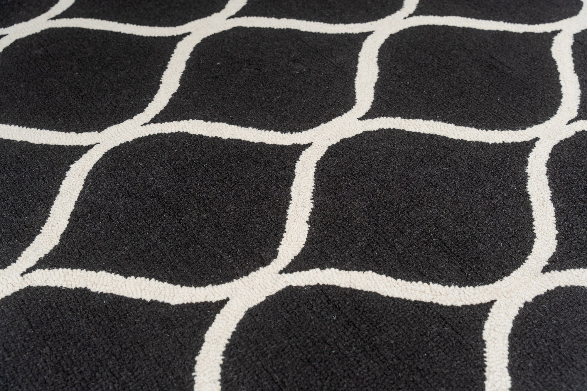 Sloane Willow Navy Hand Tufted Wool Rug, showcasing a complex, swirling floral pattern in shades of navy and cream, lending a sophisticated touch to a warmly lit living space.