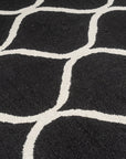 Sloane Willow Navy Hand Tufted Wool Rug, showcasing a complex, swirling floral pattern in shades of navy and cream, lending a sophisticated touch to a warmly lit living space.