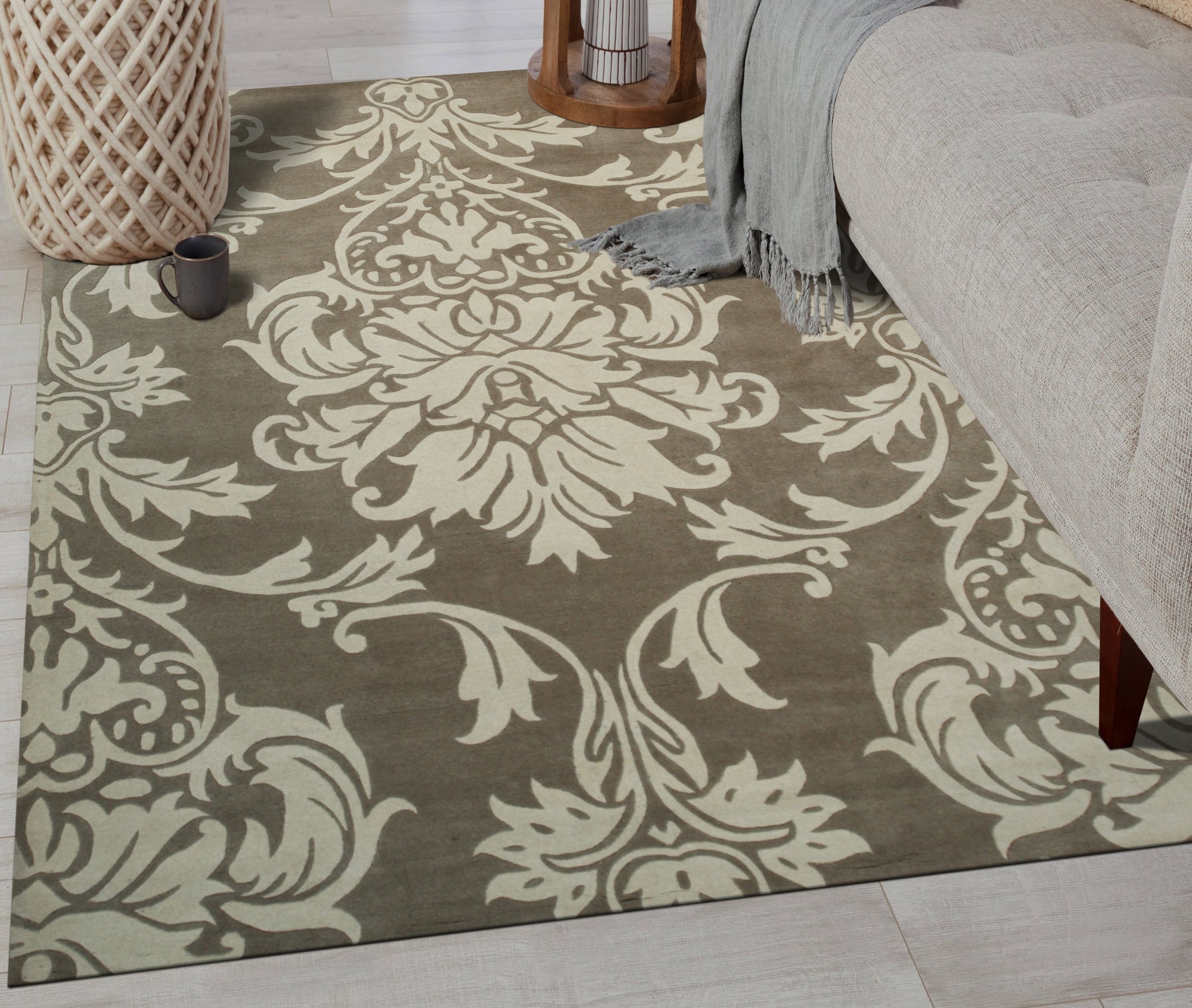 Amara Versatile Brown Hand Tufted Wool Rug, seen in a bright, inviting living room, features a subtle, organic pattern in warm browns and creams. Its hand-tufted wool construction adds texture and warmth to the neutral space.