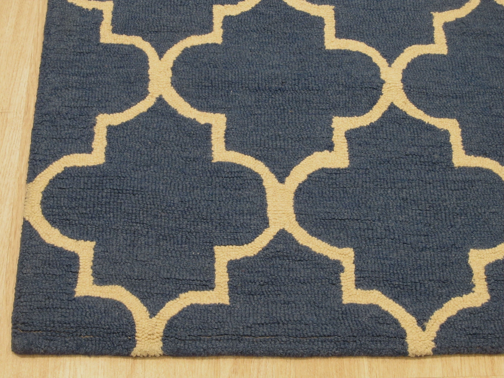 Dazzling Trellis Dark Blue Hand Tufted Wool Rug, its intricate trellis design in shades of blue and cream laid upon a dark blue field, hand-tufted from wool, adding warmth and texture to a living space.
