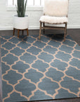 Ophelia Moroccan Midnight Hand Tufted Wool Rug, indigo and cream wool rug featuring a geometric Moroccan-inspired design, displayed in a brightly lit living room setting with contemporary furniture.