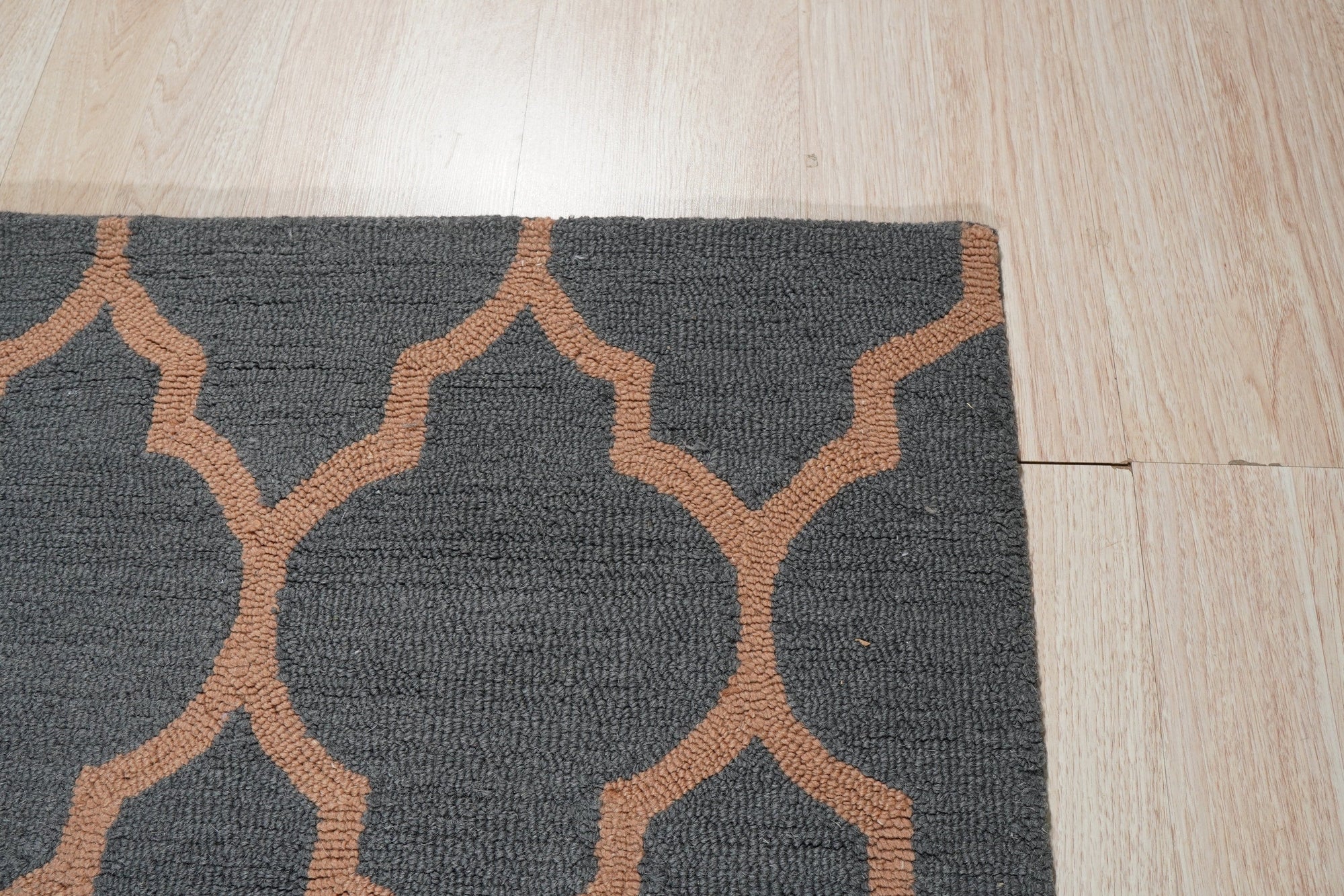 Ophelia Moroccan Midnight Hand Tufted Wool Rug, indigo and cream geometric patterns dance across a plush, hand-tufted wool surface, seen in a warmly lit room.