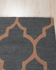 Ophelia Moroccan Midnight Hand Tufted Wool Rug, indigo and cream geometric patterns dance across a plush, hand-tufted wool surface, seen in a warmly lit room.