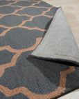 Ophelia Moroccan Midnight Hand Tufted Wool Rug, a deep midnight blue and cream wool rug featuring a geometric Moroccan-inspired design, complements a modern living room with a brown leather sofa and warm lighting.