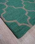 Giselle Moroccan Teal Green Hand Tufted Wool Rug, a vibrant teal and green wool rug featuring a geometric Moroccan-inspired design, softening a modern living room with a cream sofa and light wood accents.