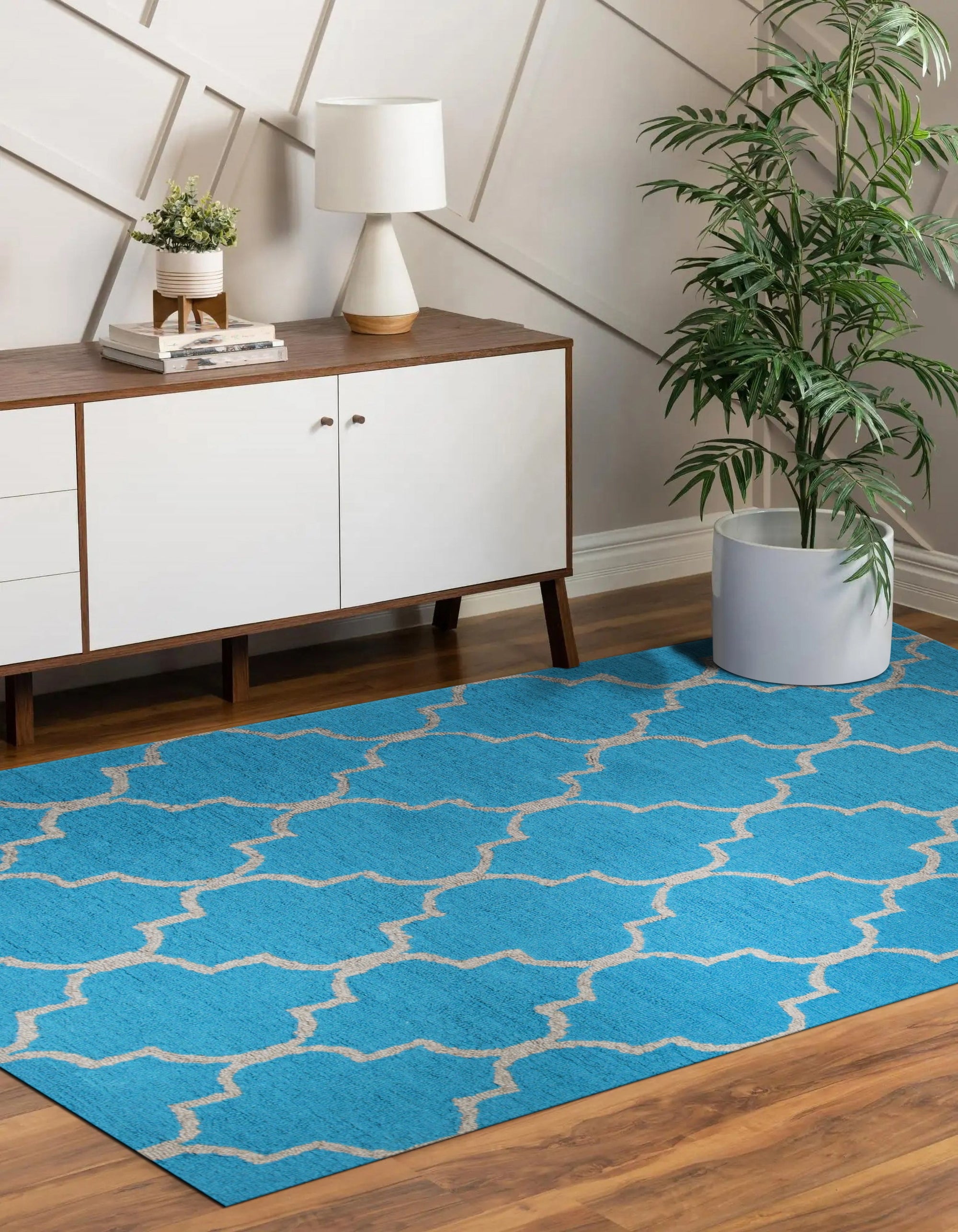 Sloane Moroccan Royal Blue Hand Tufted Wool Rug, its intricate geometric patterns in royal blue and cream create a luxurious foundation for a living space with mid-century modern furniture and ample natural light.