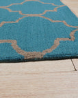 Sloane Moroccan Royal Blue Hand Tufted Wool Rug displayed within a warmly lit interior, its intricate Moroccan design and deep royal blue hues grounding the space with elegance.