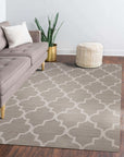 Trendy Moroccan Light Gray Hand Tufted Wool Rug anchoring a modern living room; soft light gray wool pile contrasts with a dark wooden coffee table. The hand-tufted texture is visible, suggesting a plush and inviting feel in the minimalist space.