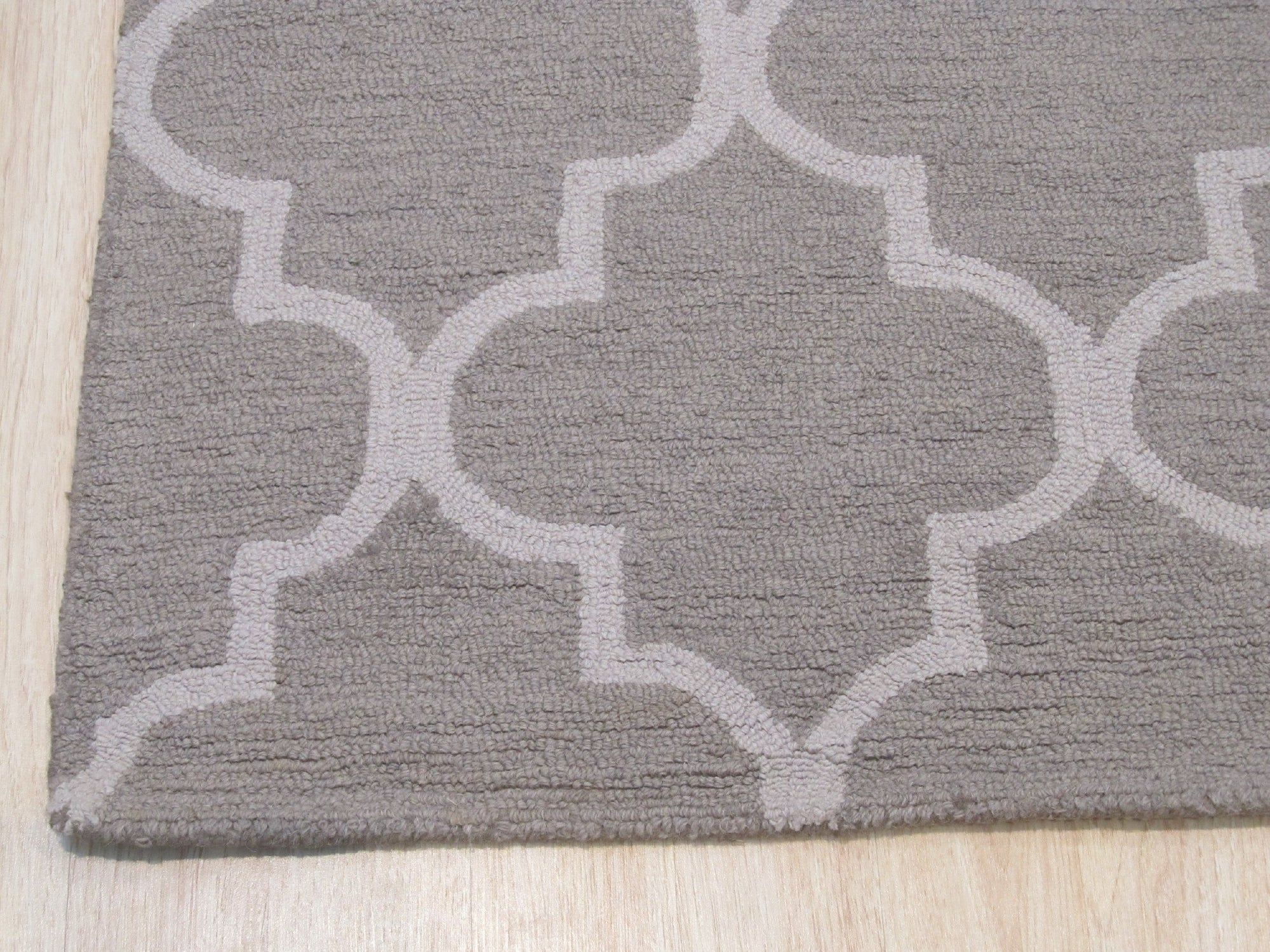 Trendy Moroccan Light Gray Hand Tufted Wool Rug, its soft, light gray wool pile adding subtle texture and warmth to a modern living room setting with neutral furniture.