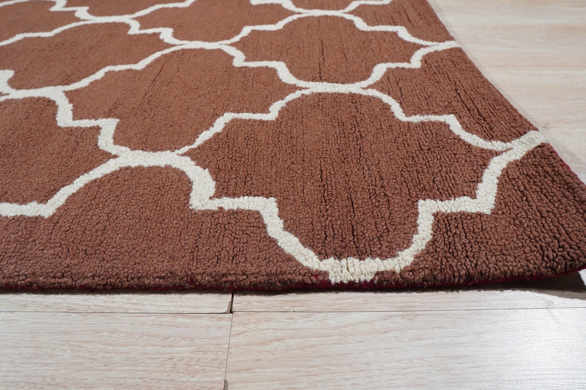 Trendy Moroccan Rust Hand Tufted Wool Rug, a rich rust and cream rug featuring a geometric Moroccan-inspired design, adds warmth and texture to a living space.