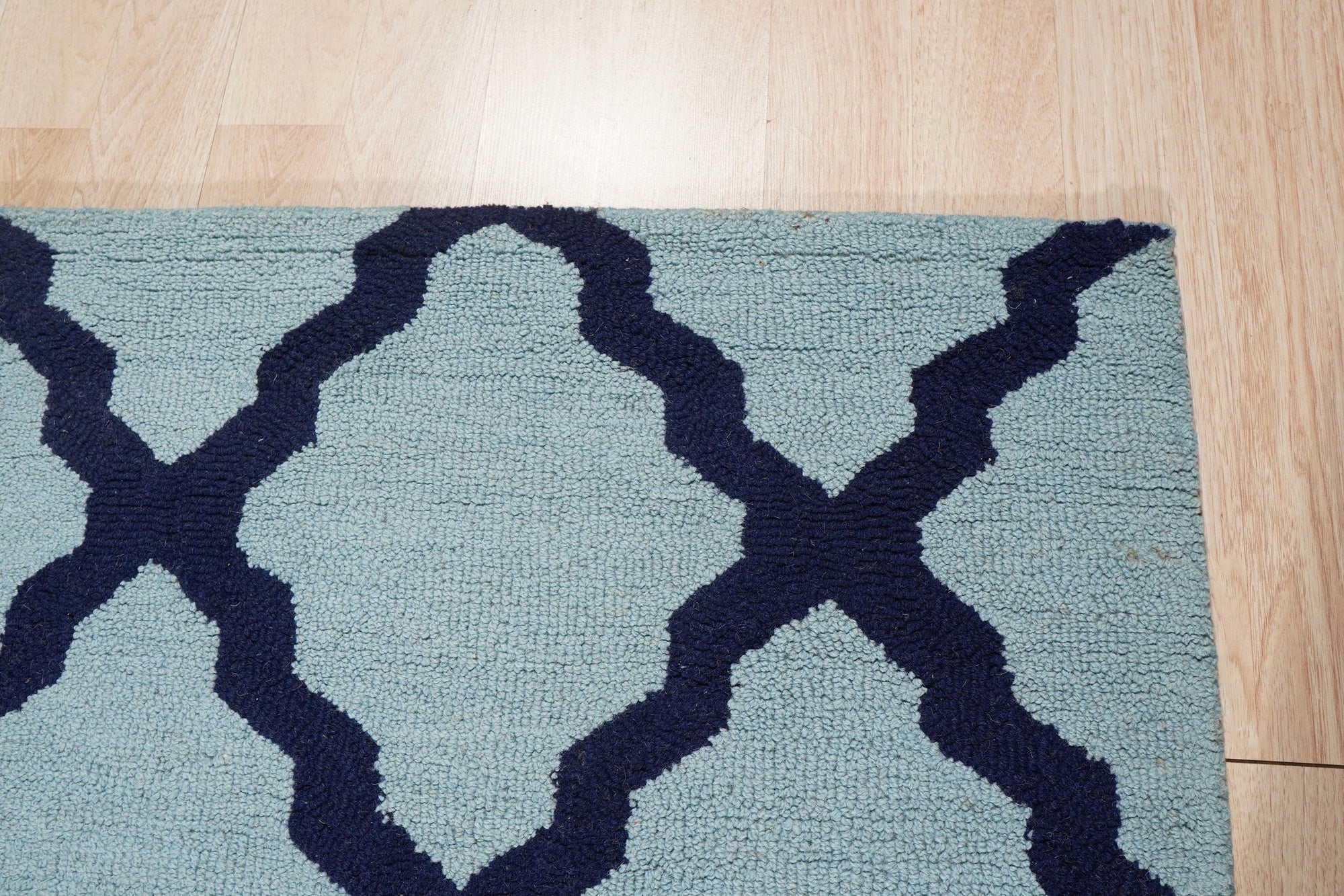 Bianca Trellis Sea Blue Hand Tufted Wool Rug, a soft sea blue wool rug with a classic trellis design, displayed in a bright, modern living space.
