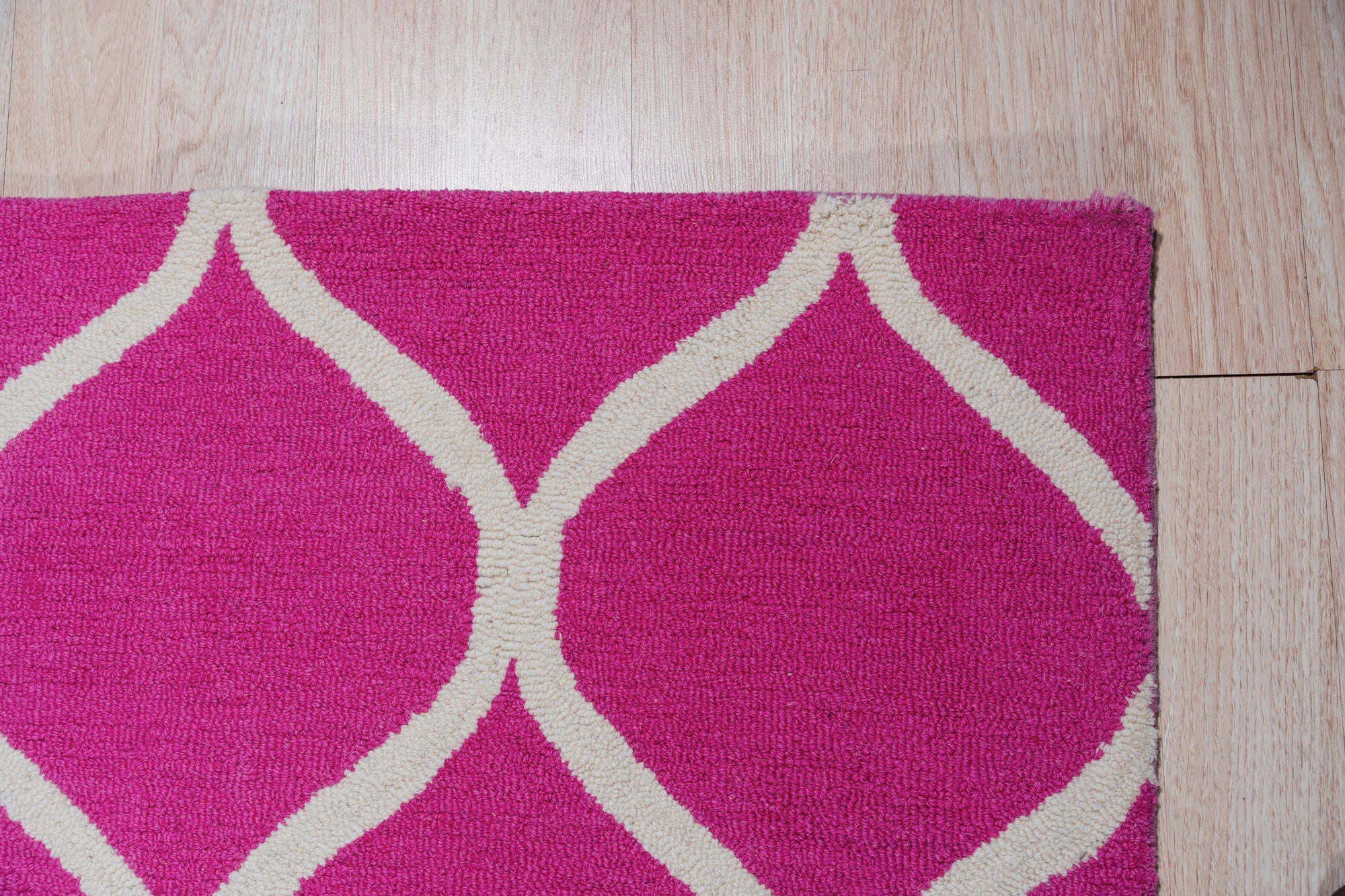 Willow Ella Pink Hand Tufted Wool Rug, a soft pink wool rug with a subtle, textured design, displayed in a bright, modern living room setting.