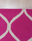 Willow Ella Pink Hand Tufted Wool Rug, a soft pink wool rug with a subtle, textured design, displayed in a bright, modern living room setting.