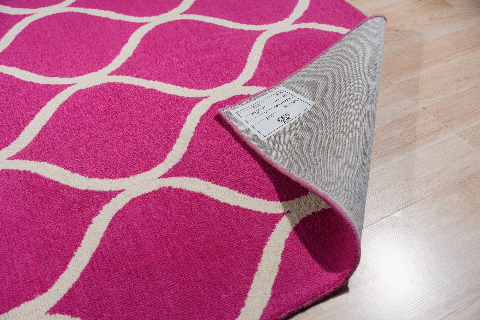 Willow Ella Pink Hand Tufted Wool Rug, displaying soft pink hues and a subtle, textured pattern, layered in a bright, naturally lit room with neutral furniture and hardwood flooring.