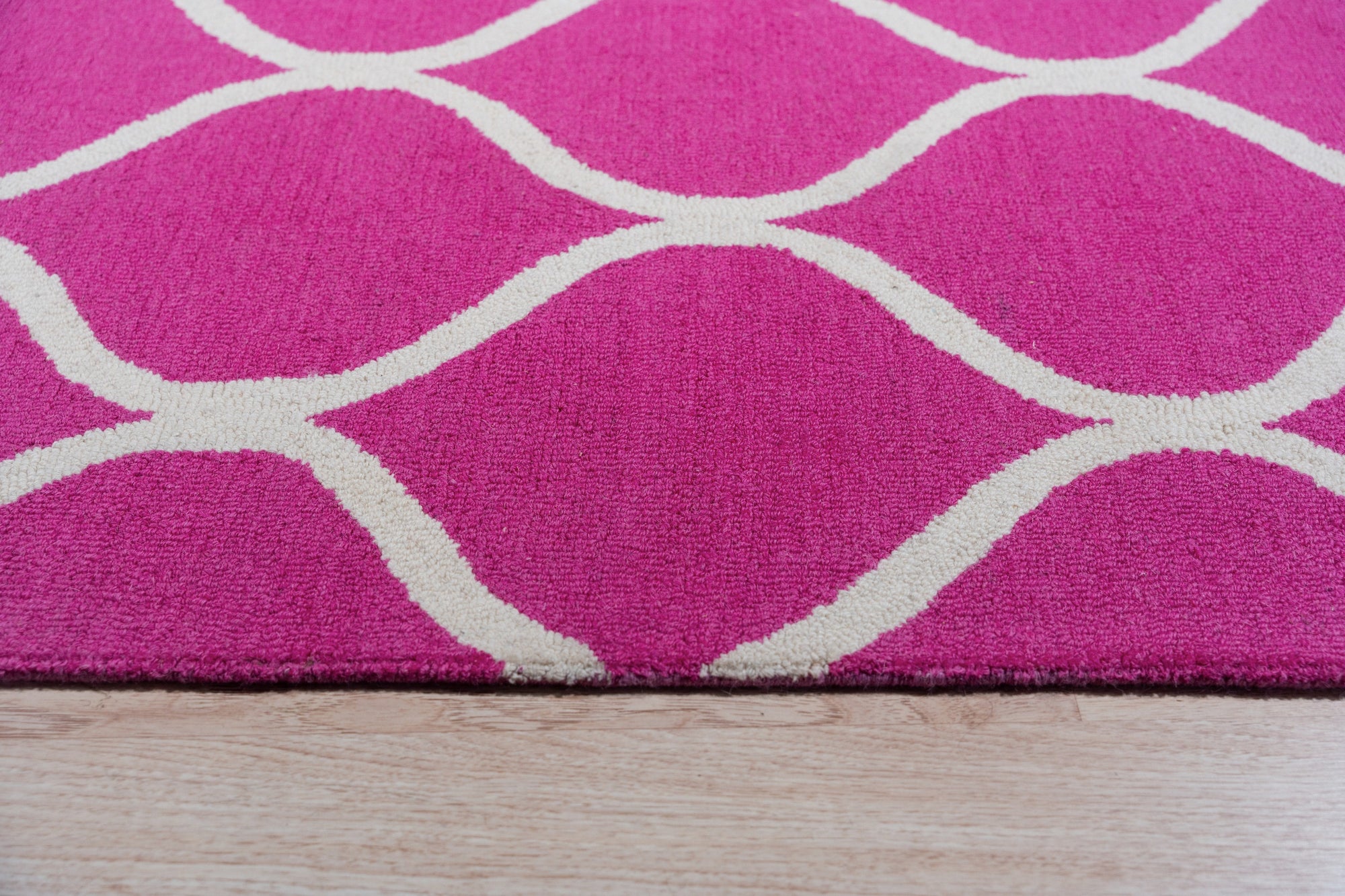 Willow Ella Pink Hand Tufted Wool Rug, soft pink wool blooms across a subtly patterned background, creating a comforting texture underfoot in a brightly lit room.