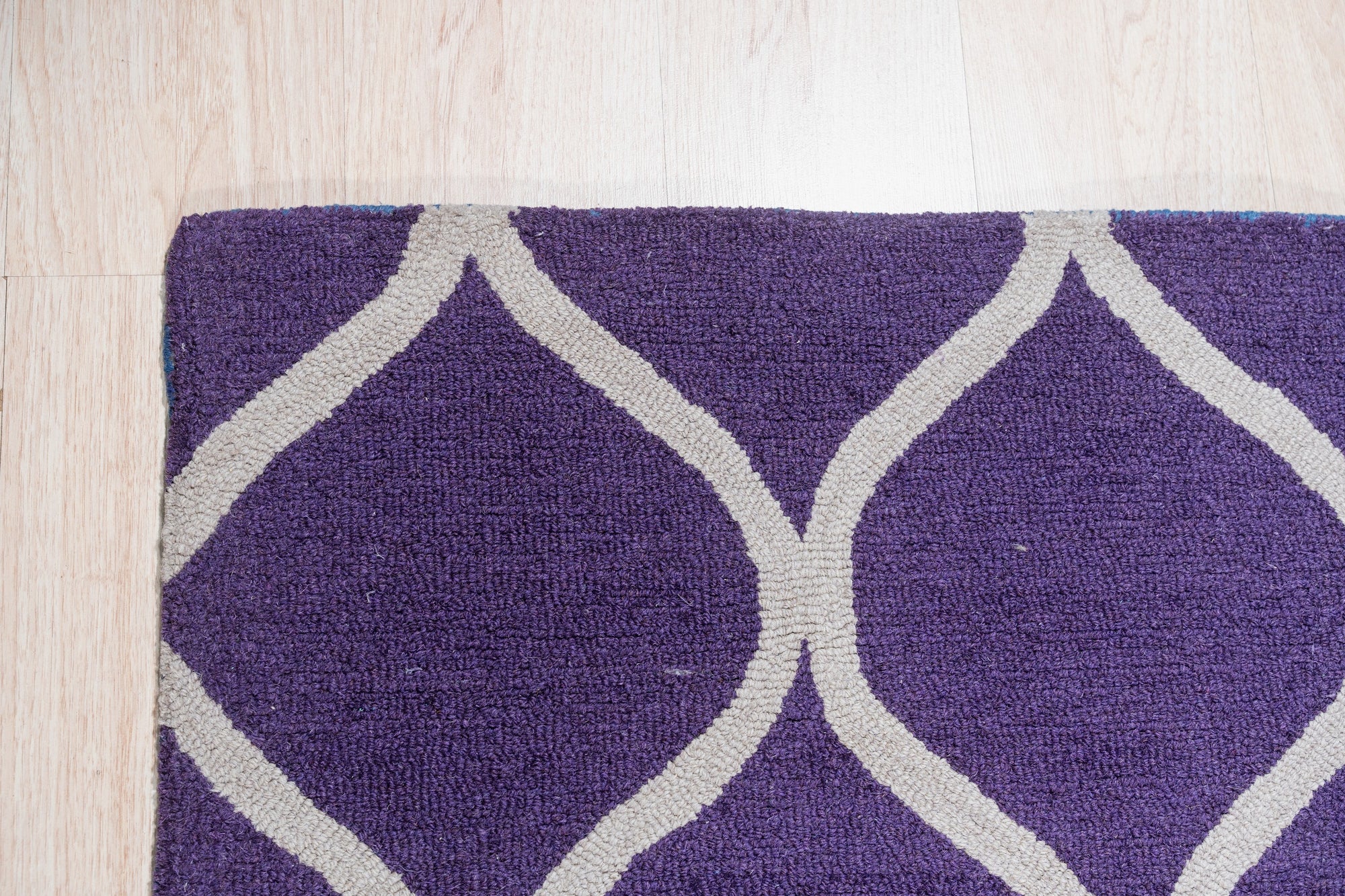 Lush Handcrafted Purple Hand Tufted Wool Rug, a plush expanse of rich purple wool, its hand-tufted construction evident in the luxurious pile and subtle textural variations, inviting touch and adding a touch of regal comfort to any space.