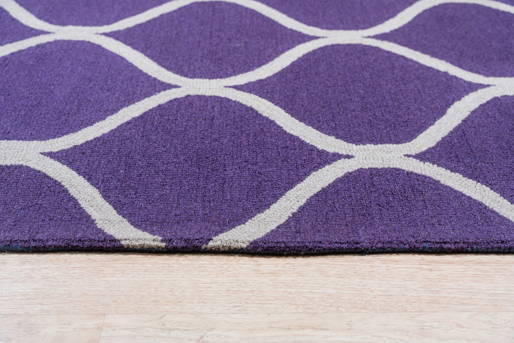 Lush Handcrafted Purple Hand Tufted Wool Rug, showcasing a rich, saturated purple hue and plush hand-tufted texture. The rug presents a luxurious and inviting feel, displayed in a room setting that highlights its soft pile and vibrant color.
