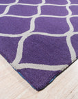Lush Handcrafted Purple Hand Tufted Wool Rug, luxurious deep purple wool pile invites touch. Hand-tufted construction creates a plush texture, seen in a close-up showcasing the rug's craftsmanship.