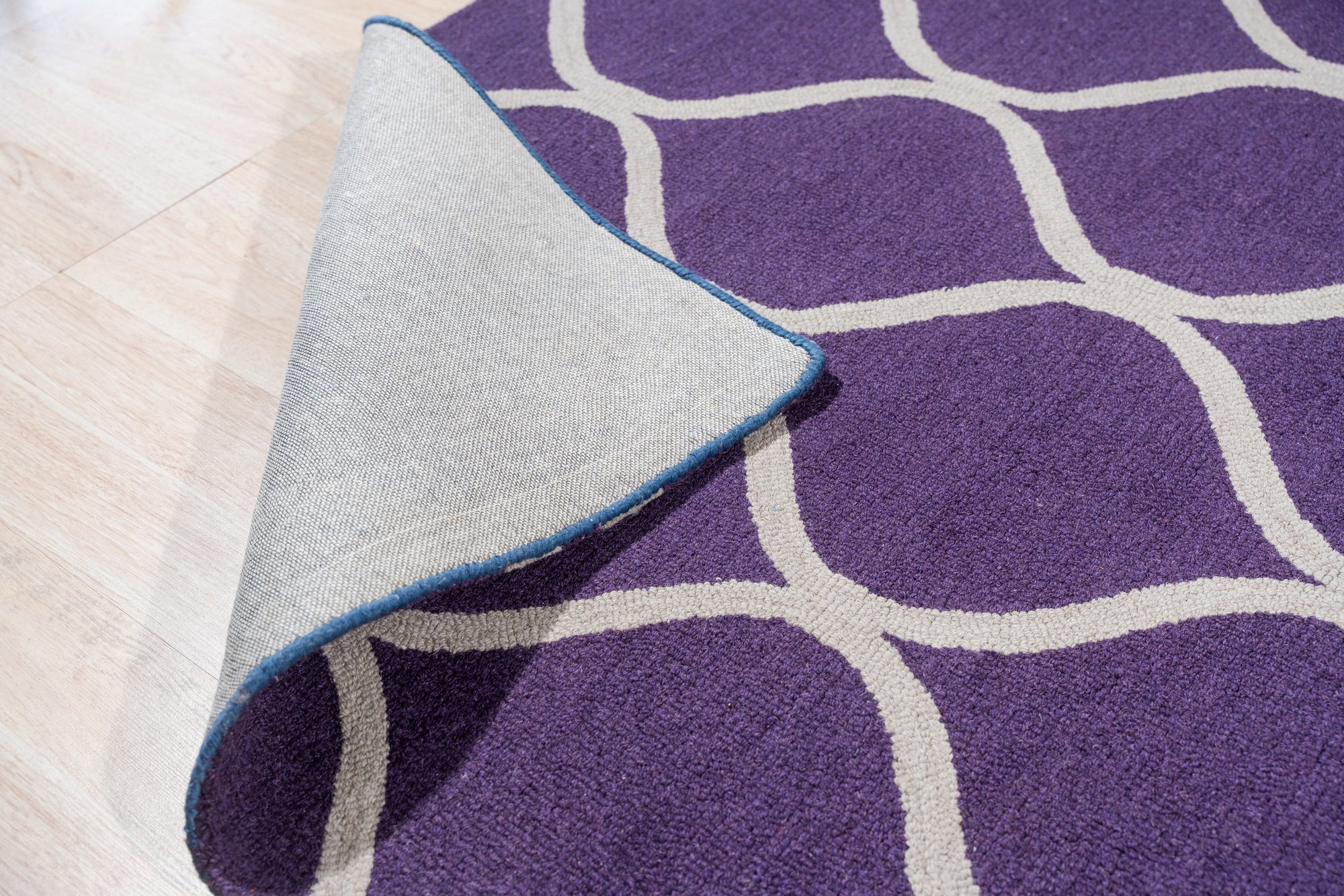 Lush Handcrafted Purple Hand Tufted Wool Rug, deep violet hand-tufted wool creating a plush, luxurious texture, showcasing subtle variations in the purple dye across its thick pile.