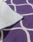 Lush Handcrafted Purple Hand Tufted Wool Rug, deep violet hand-tufted wool creating a plush, luxurious texture, showcasing subtle variations in the purple dye across its thick pile.