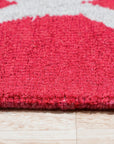 Delicate Enchanting Red Hand Tufted Wool Rug, a vibrant red wool rug with a detailed, possibly floral or geometric design, shown in a room setting, potentially a living room or bedroom.