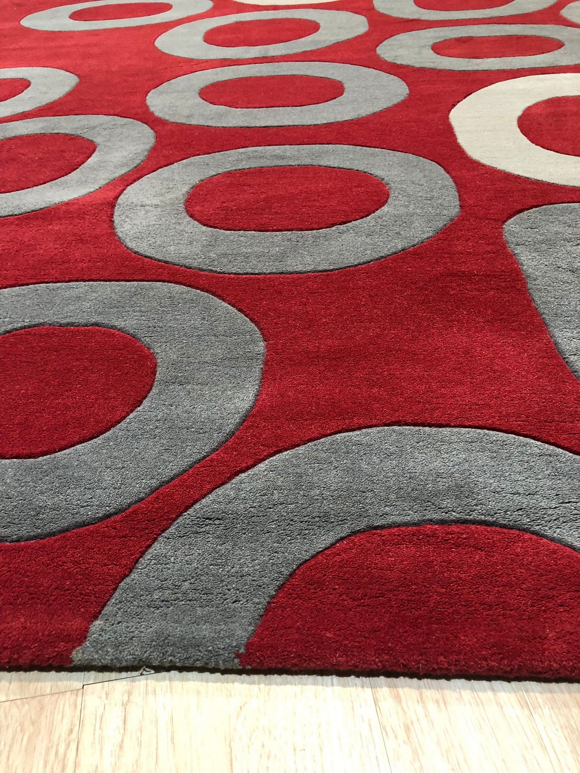 Willow Lila Red Hand Tufted Wool Rug, vibrant red hues and intricate patterns grace this hand-tufted wool rug, bringing warmth and texture to an unseen room.