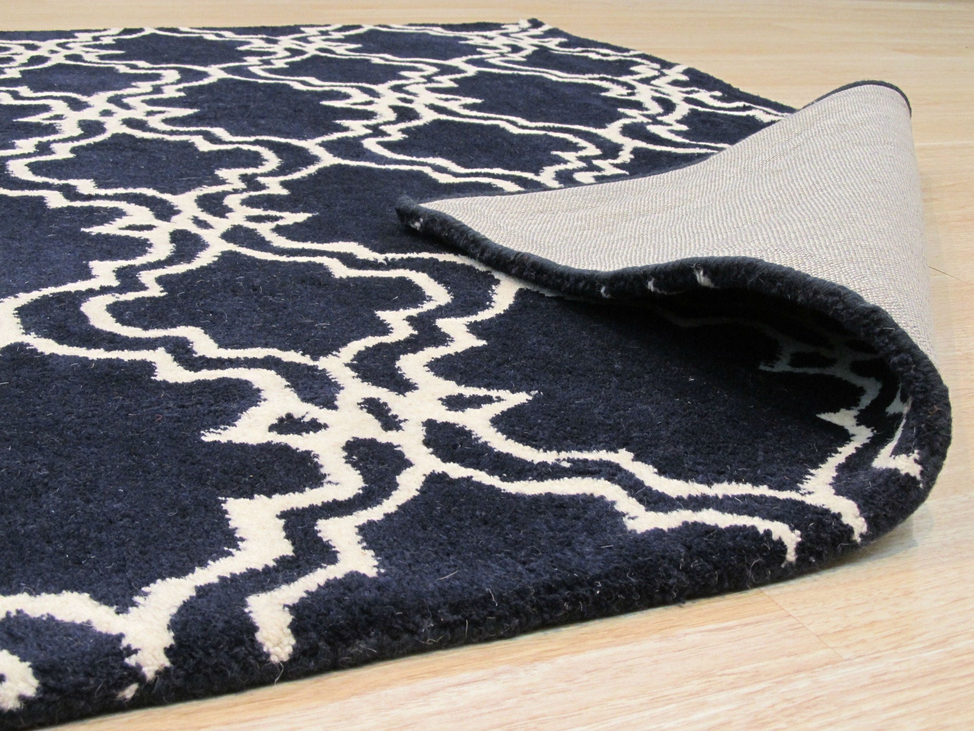 Penelope Moroccan Blue Hand Tufted Wool Rug, showcasing intricate geometric patterns in shades of blue and cream, lending an air of sophisticated comfort to a stylishly decorated living room.