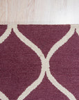 Ava Exquisite Burgundy Hand Tufted Wool Rug, showcasing rich burgundy tones and intricate hand-tufted details, adds warmth and texture to a softly lit room with neutral-toned furniture.