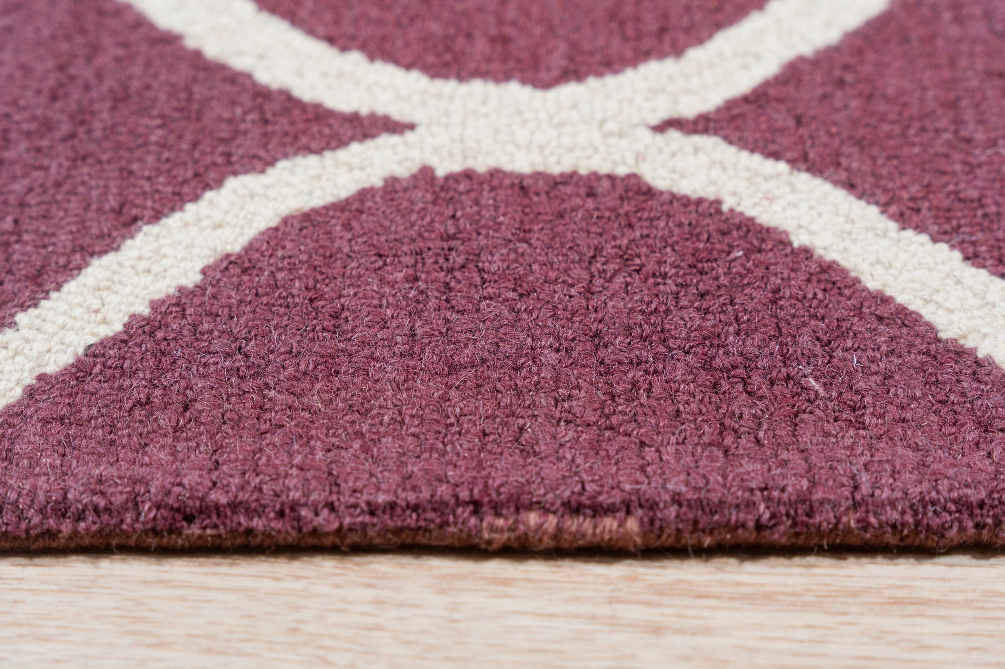Ava Exquisite Burgundy Hand Tufted Wool Rug, its rich burgundy hues and intricate hand-tufted design showcased within a warm, inviting living space.