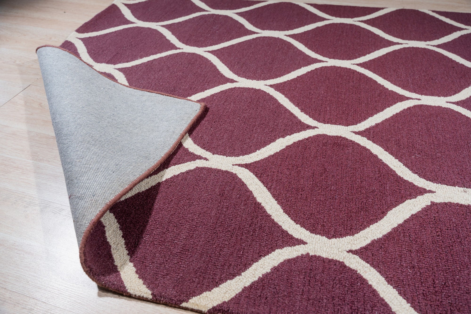 Ava Exquisite Burgundy Hand Tufted Wool Rug, its deep burgundy hues and hand-tufted texture showcased in a detailed view, highlighting its luxurious wool construction and intricate pattern.