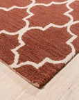 Giselle Iris Brown Hand Tufted Wool Rug displayed in a brightly lit room, showcasing its intricate floral pattern and soft texture. The rug anchors the space, complementing the neutral furniture.