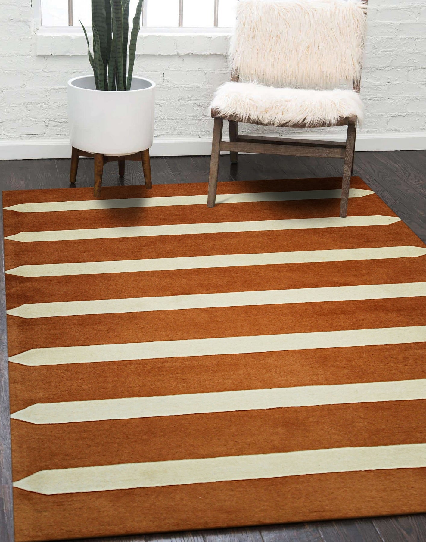 Louie Elena Rust Hand Tufted Wool Rug displayed in a living room setting. Warm rust tones and hand-tufted texture create a cozy, inviting atmosphere against neutral furniture and natural light.