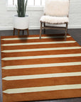 Louie Elena Rust Hand Tufted Wool Rug displayed in a living room setting. Warm rust tones and hand-tufted texture create a cozy, inviting atmosphere against neutral furniture and natural light.