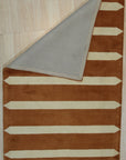 Louie Elena Rust Hand Tufted Wool Rug, its textured surface displaying earthy rust tones and subtle variations in the wool, fills the frame with warmth and inviting comfort.