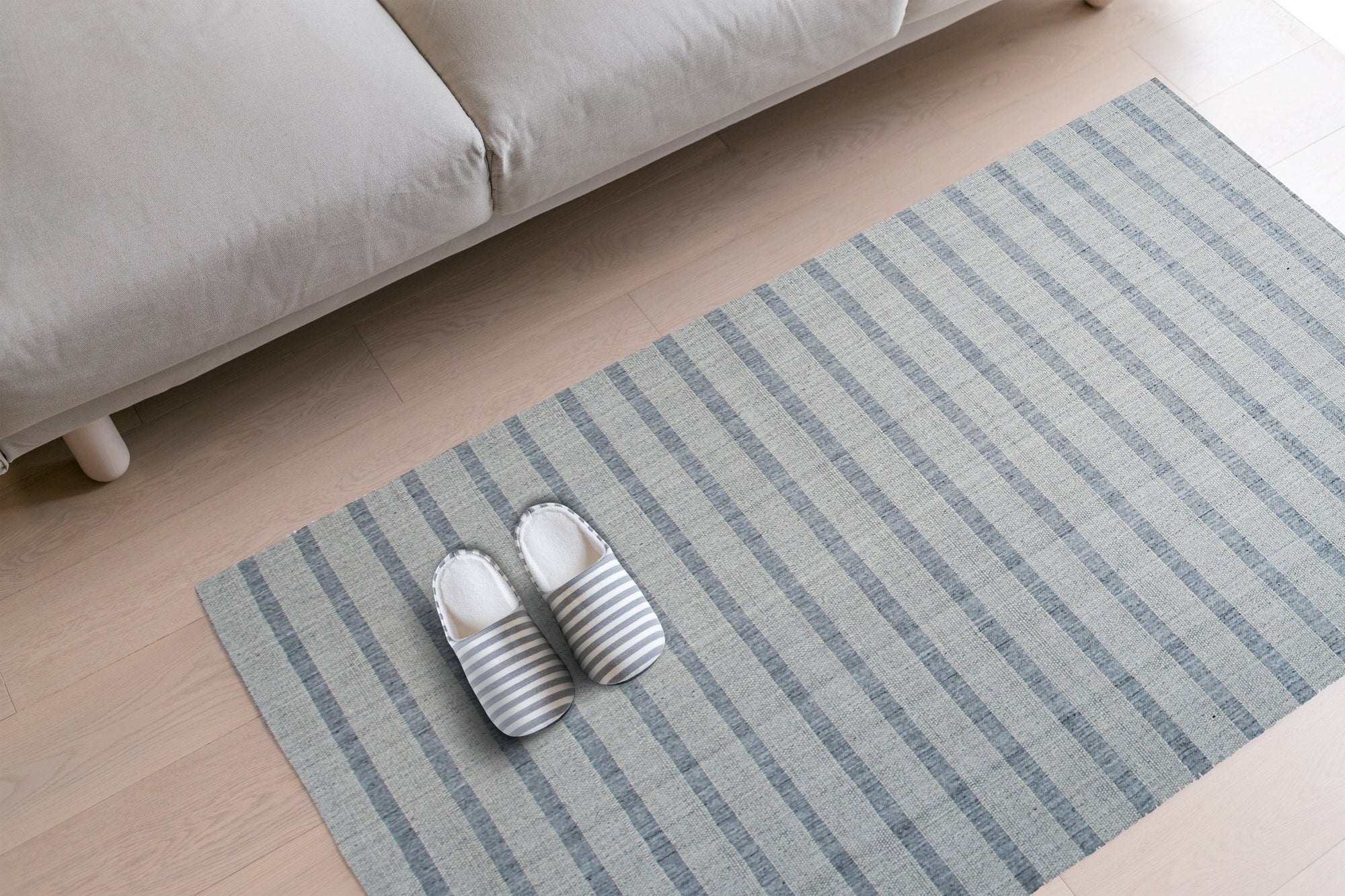 Luxurious Timeless Gray Handmade Wool Rug anchors a serene living room. Soft grey wool pile invites bare feet, complementing light wood floors and minimalist furniture. Natural light highlights subtle variations in the rug's hand-knotted construction and neutral color palette.