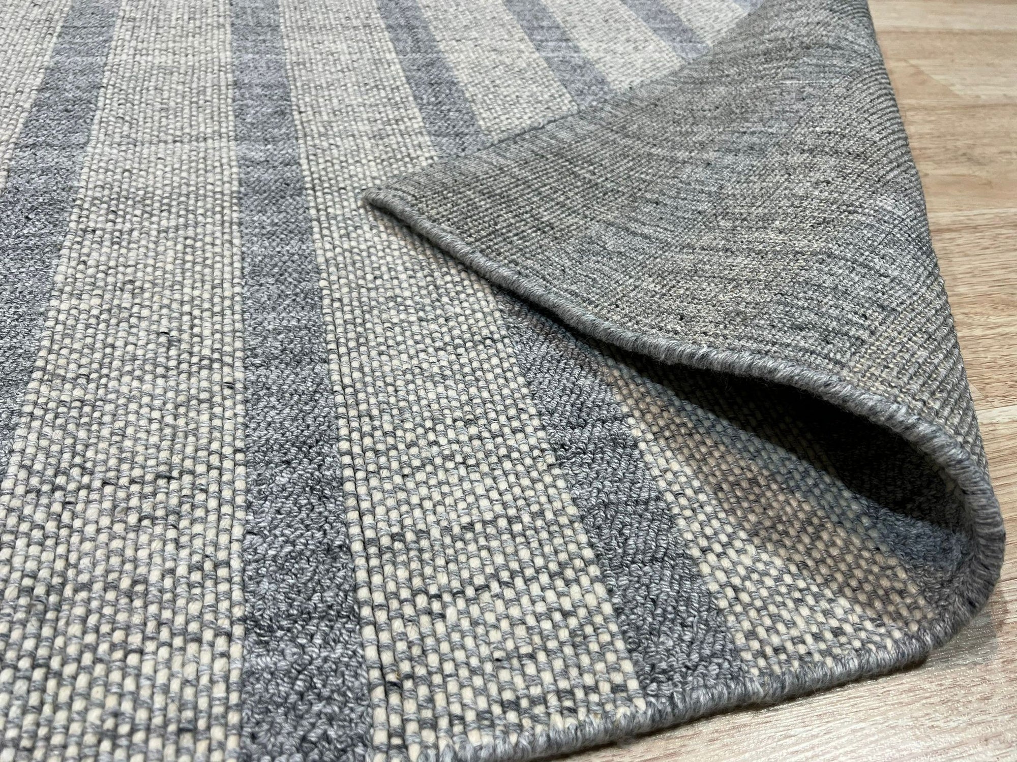 Luxurious Timeless Gray Handmade Wool Rug, grounding a modern living room, its soft gray tones complementing neutral furniture and adding warmth underfoot.