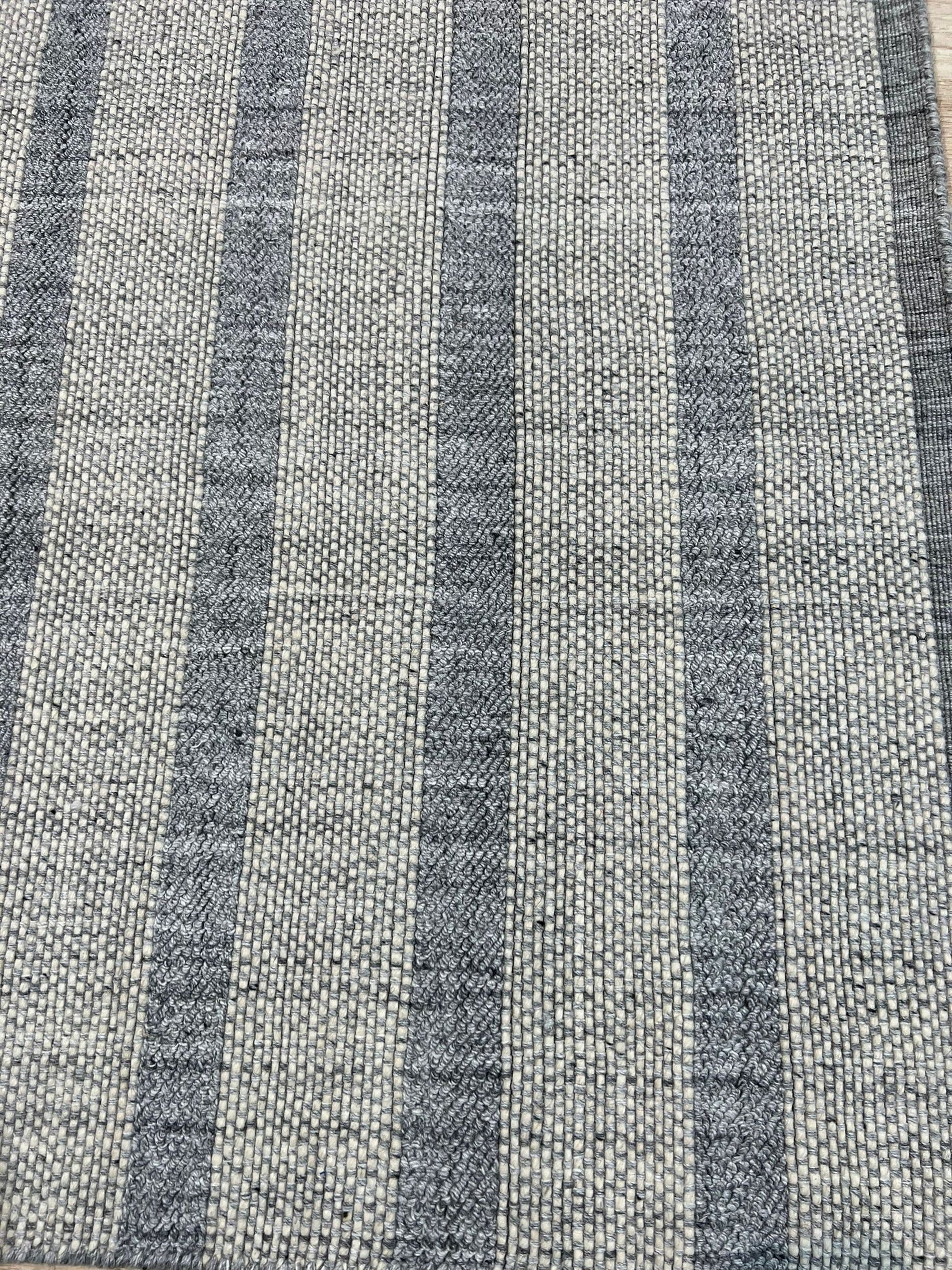 Luxurious Timeless Gray Handmade Wool Rug, woven with a subtle texture in a versatile gray, softly grounds a warmly lit living space.