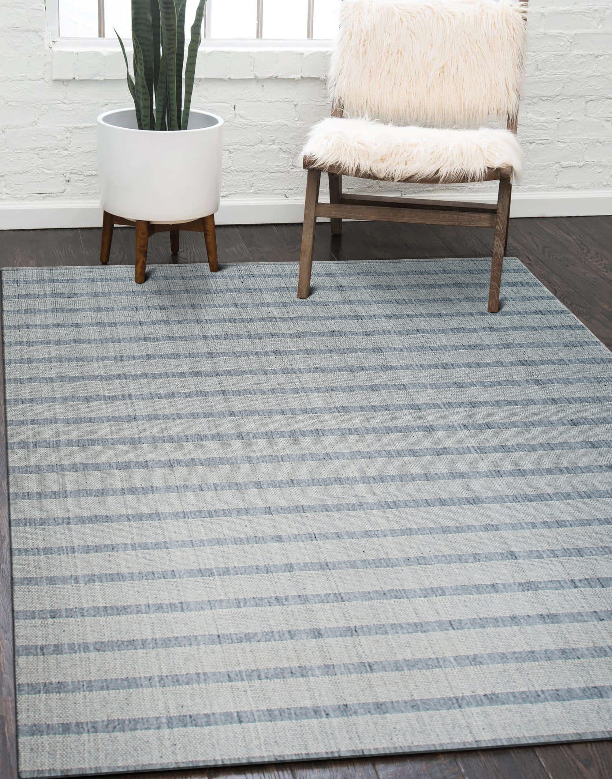 Luxurious Timeless Gray Handmade Wool Rug, its soft gray tones and textured weave visible, laying on hardwood floors with a hint of natural light filtering through the scene.