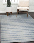 Luxurious Timeless Gray Handmade Wool Rug, its soft gray tones and textured weave visible, laying on hardwood floors with a hint of natural light filtering through the scene.