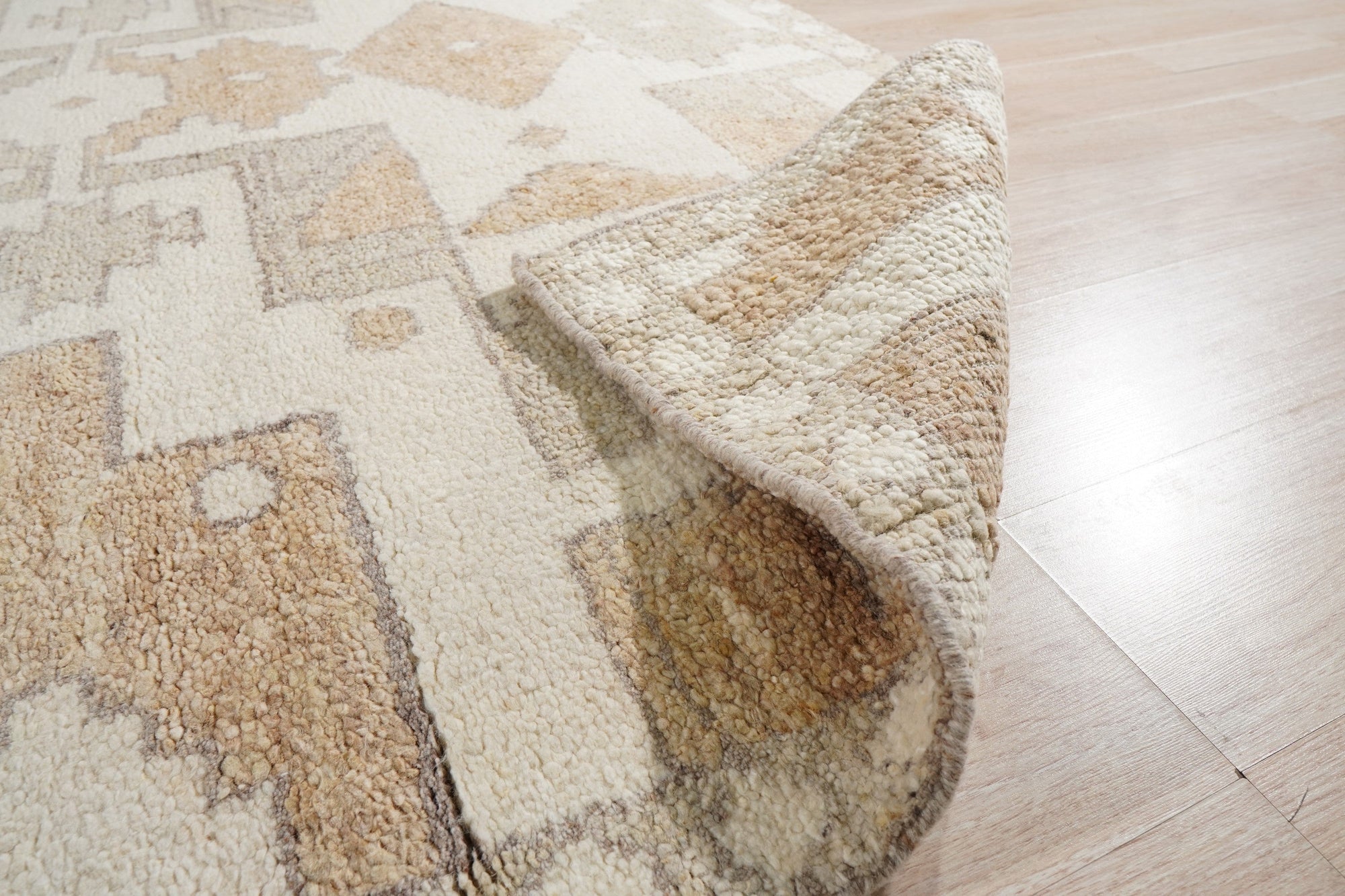 Inviting Oushak Ivory Hand Knotted Wool Rug, an ivory wool rug with a traditional Oushak design, displayed on a light-colored hardwood floor.