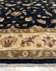 Stylish Peshawar Navy Hand Knotted Wool Rug, its rich navy hues and intricate hand-knotted details accent a room setting with warm lighting.