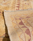 Violet Elegant Beige Hand Knotted Wool Rug, showcasing a detailed floral pattern in beige and violet hues, lies on a light hardwood floor, lending warmth and sophistication to a minimalist space.