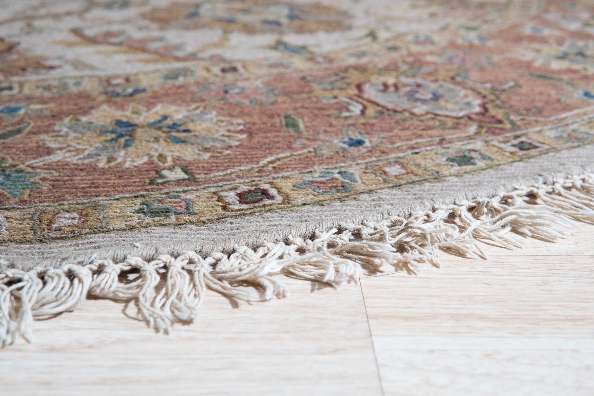 Comfortable Timeless Ivory Hand Knotted Wool Rug, showcasing soft ivory tones and intricate hand-knotted texture, rests on a light wood floor, suggesting warmth and understated elegance in a minimalist setting.