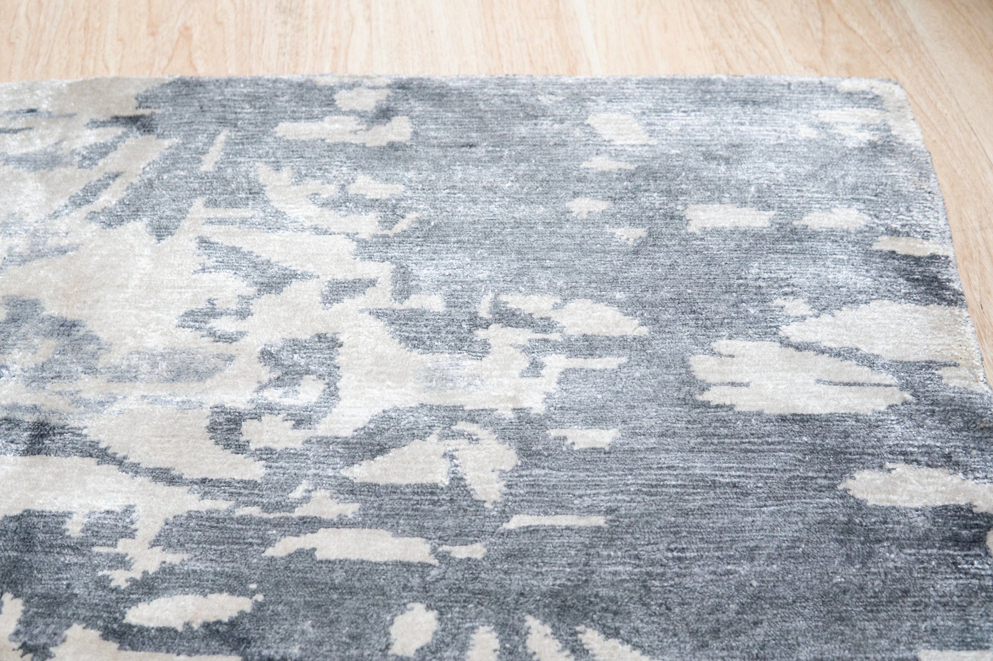 Amara Rhea Ivory Hand Knotted Rug, displaying intricate knotted construction and soft ivory hues, situated in a well-lit interior setting.